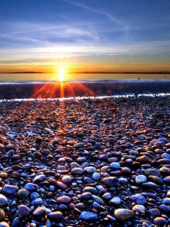 Das Beach Pebbles In Sun Lights At Sunrise Wallpaper 240x320