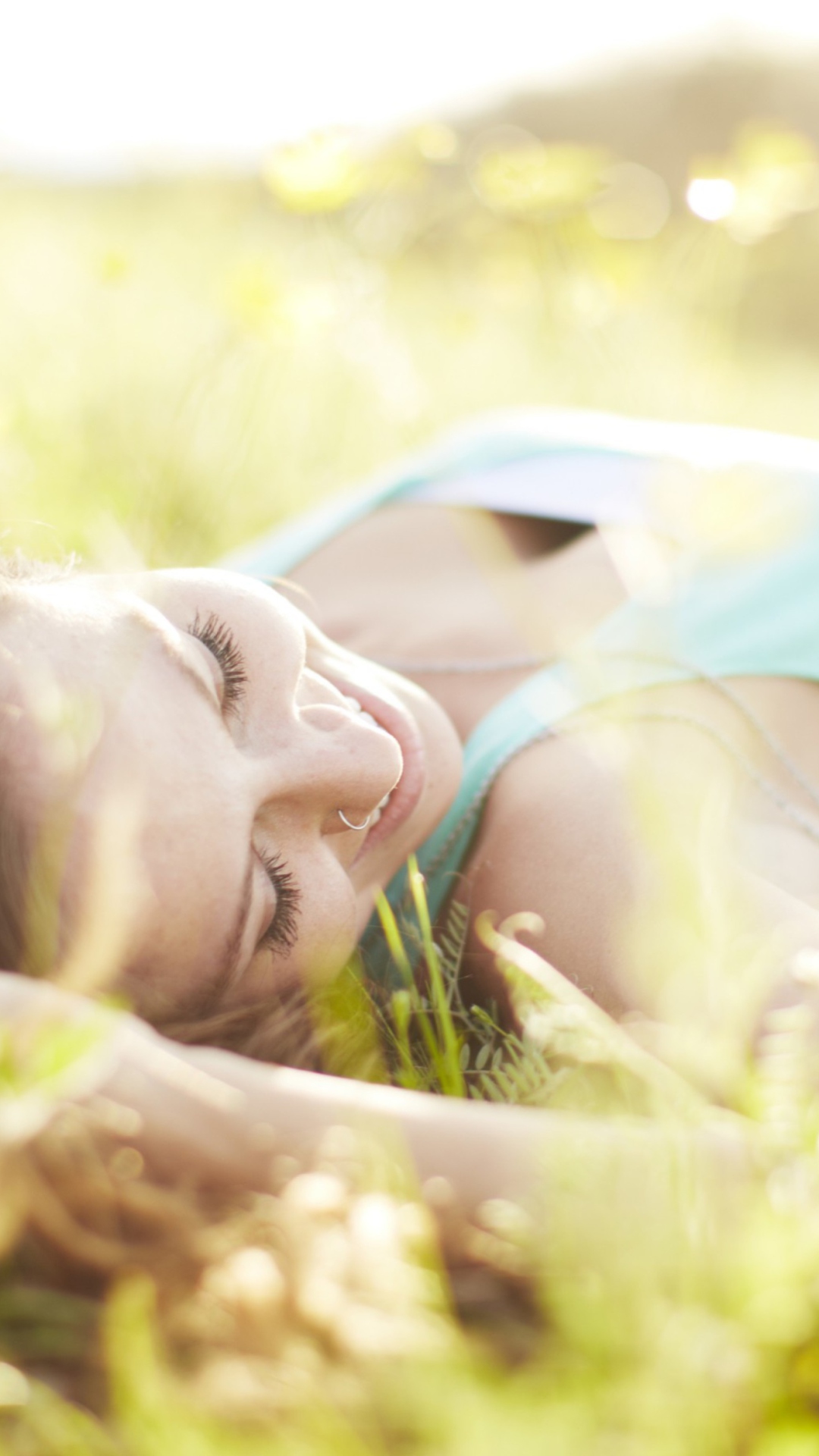 Das Happy Girl Lying In Grass In Sunlight Wallpaper 1080x1920