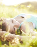 Happy Girl Lying In Grass In Sunlight wallpaper 128x160