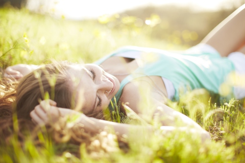 Sfondi Happy Girl Lying In Grass In Sunlight 480x320