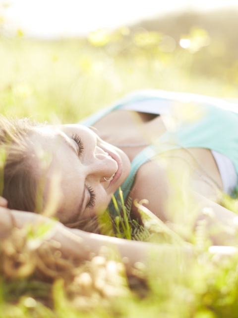 Fondo de pantalla Happy Girl Lying In Grass In Sunlight 480x640