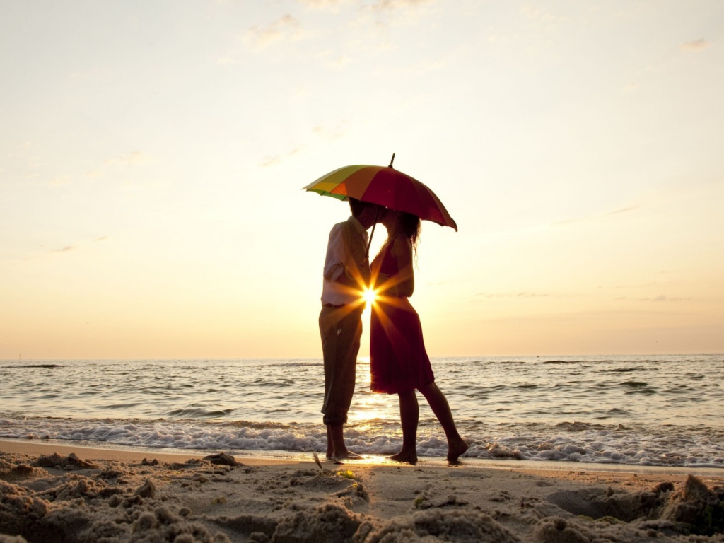 Das Couple Kissing Under Umbrella At Sunset On Beach Wallpaper 1024x768