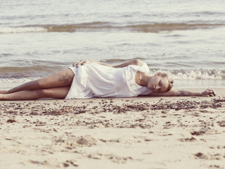 Обои Blonde Girl Lying On Beach 320x240