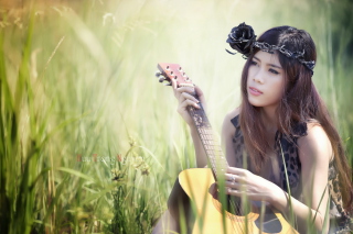 Pretty Girl In Grass Playing Guitar - Obrázkek zdarma 