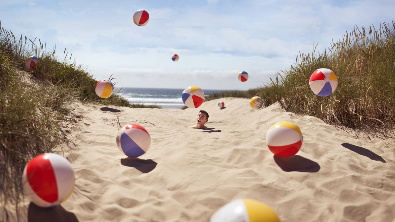 Sfondi Beach Balls And Man's Head In Sand 1600x900