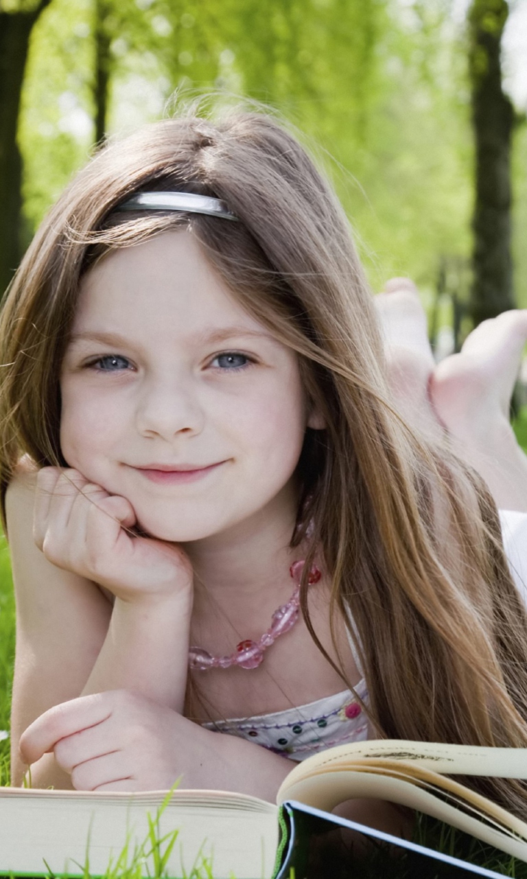 Cute Little Girl Reading Book In Garden wallpaper 768x1280