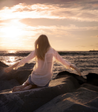 Girl Sitting On Stones On Sea Coast - Obrázkek zdarma pro Nokia Asha 311
