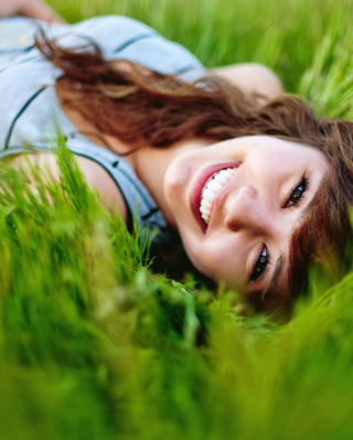 Smiling Girl Lying In Green Grass - Obrázkek zdarma pro iPhone 5S