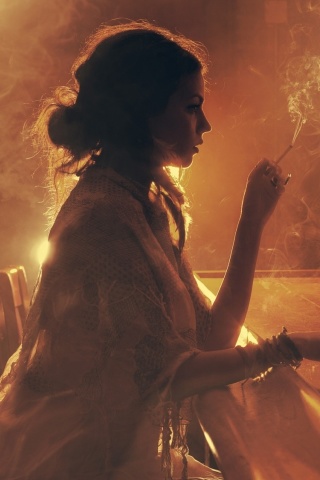 Sad girl with cigarette in bar wallpaper 320x480