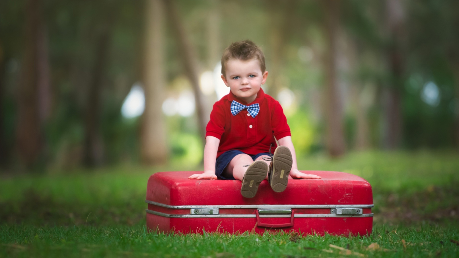 Fondo de pantalla Cute Boy Sitting On Red Luggage 1600x900