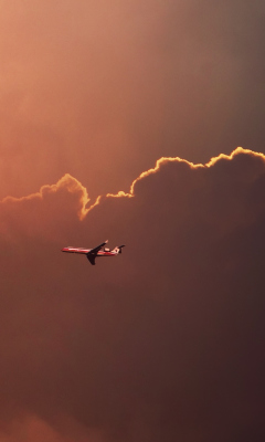 Fondo de pantalla Airplane In Red Sky Above Clouds 240x400
