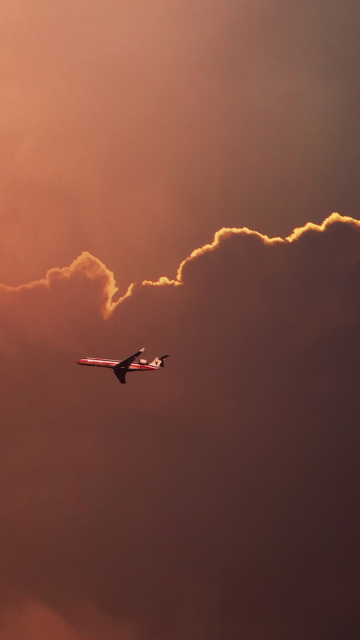 Обои Airplane In Red Sky Above Clouds 360x640