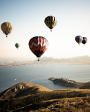 Das Air Balloons In Sky Above Ground Wallpaper 128x160