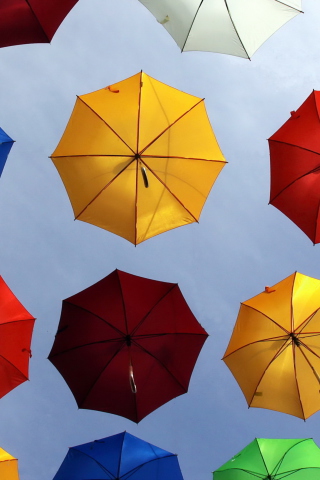 Fondo de pantalla Colorful Umbrellas In Blue Sky 320x480