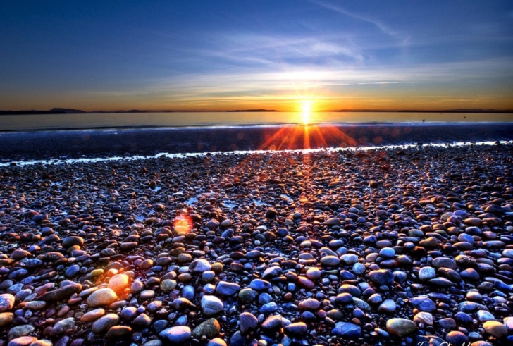 Обои Beach Pebbles In Sun Lights At Sunrise