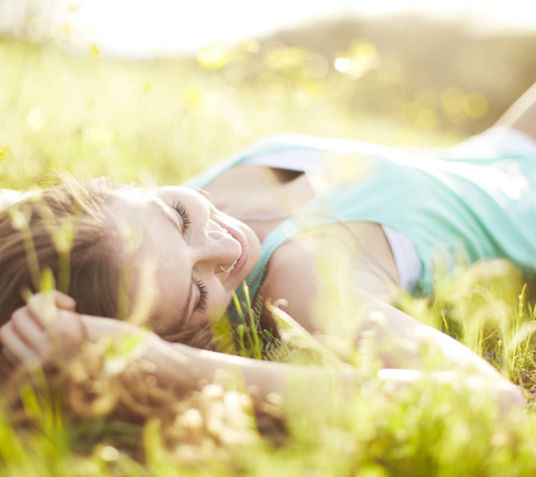 Das Happy Girl Lying In Grass In Sunlight Wallpaper 1080x960