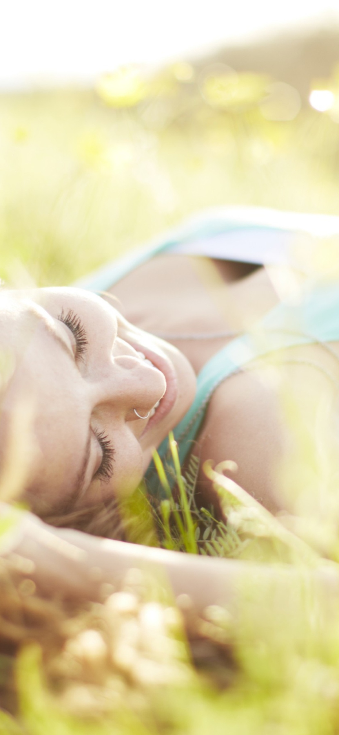 Das Happy Girl Lying In Grass In Sunlight Wallpaper 1170x2532