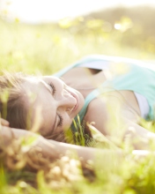 Happy Girl Lying In Grass In Sunlight wallpaper 176x220
