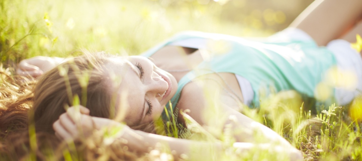Sfondi Happy Girl Lying In Grass In Sunlight 720x320
