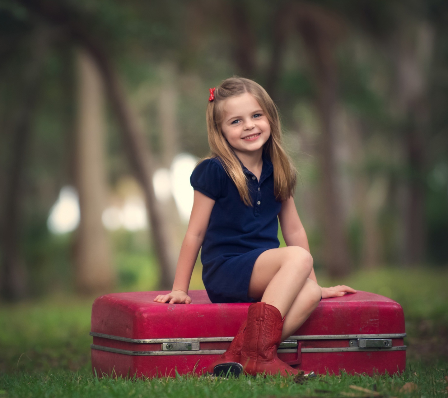 Обои Little Girl Sitting On Red Suitcase 1440x1280