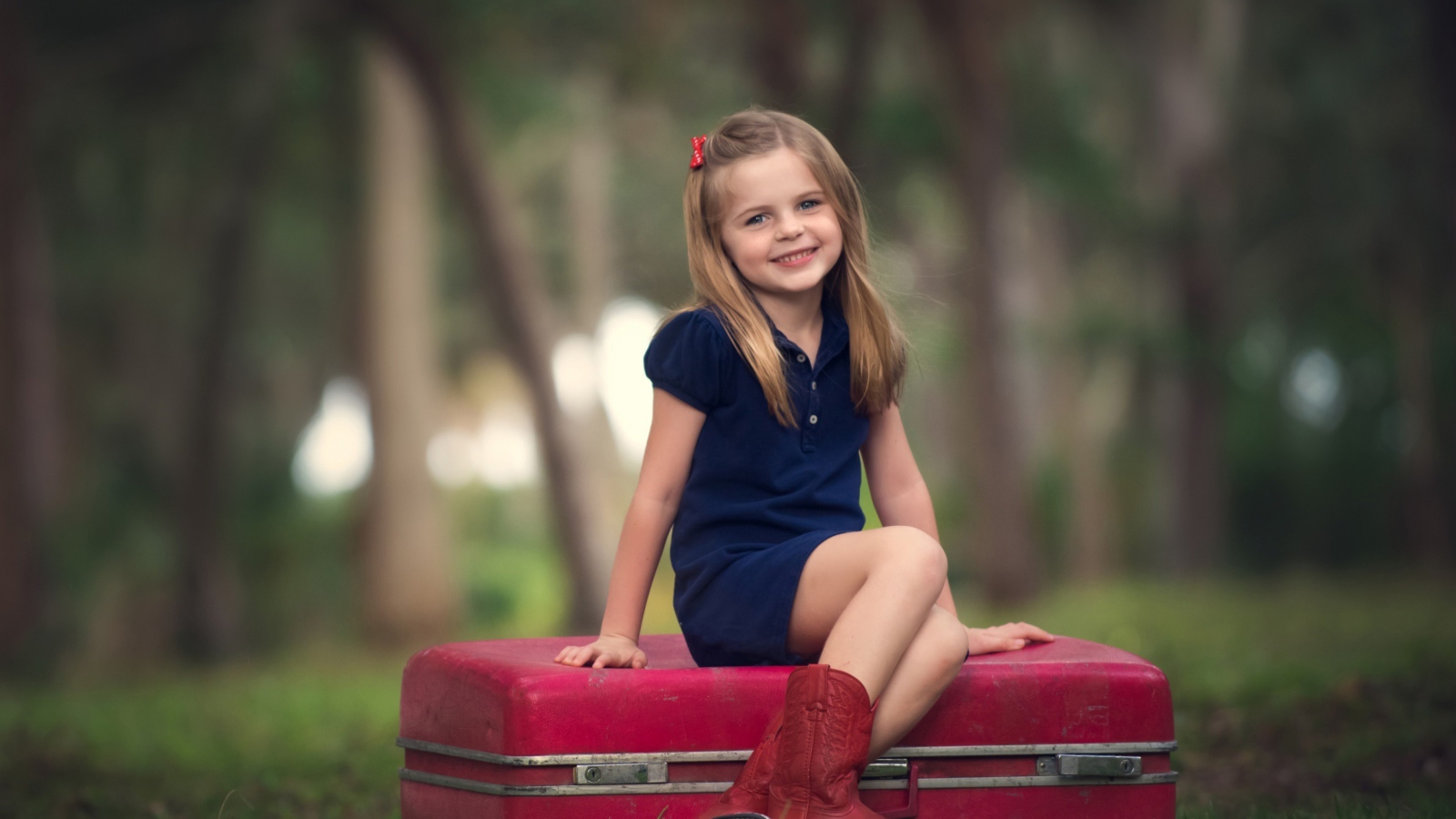 Обои Little Girl Sitting On Red Suitcase 1600x900