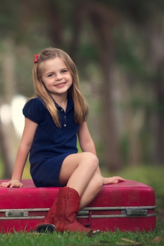 Обои Little Girl Sitting On Red Suitcase 320x480