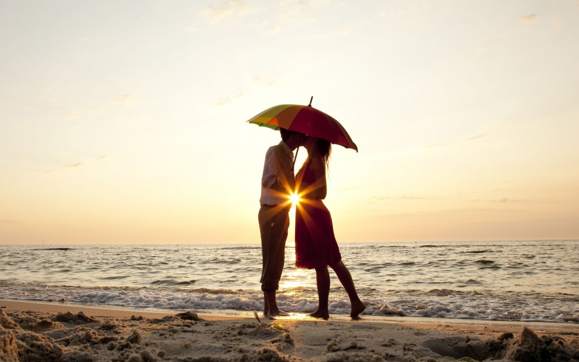 Fondo de pantalla Couple Kissing Under Umbrella At Sunset On Beach 1920x1200