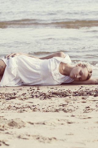 Sfondi Blonde Girl Lying On Beach 320x480