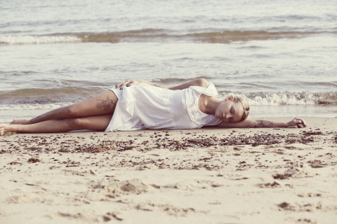 Обои Blonde Girl Lying On Beach 480x320
