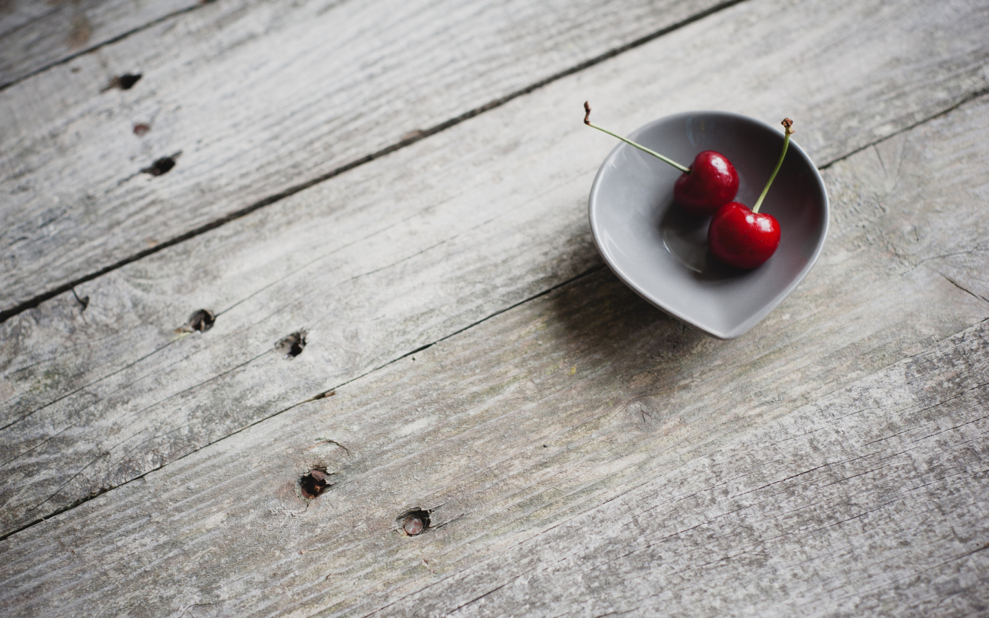 Das Two Red Cherries On Plate On Wooden Table Wallpaper 1440x900