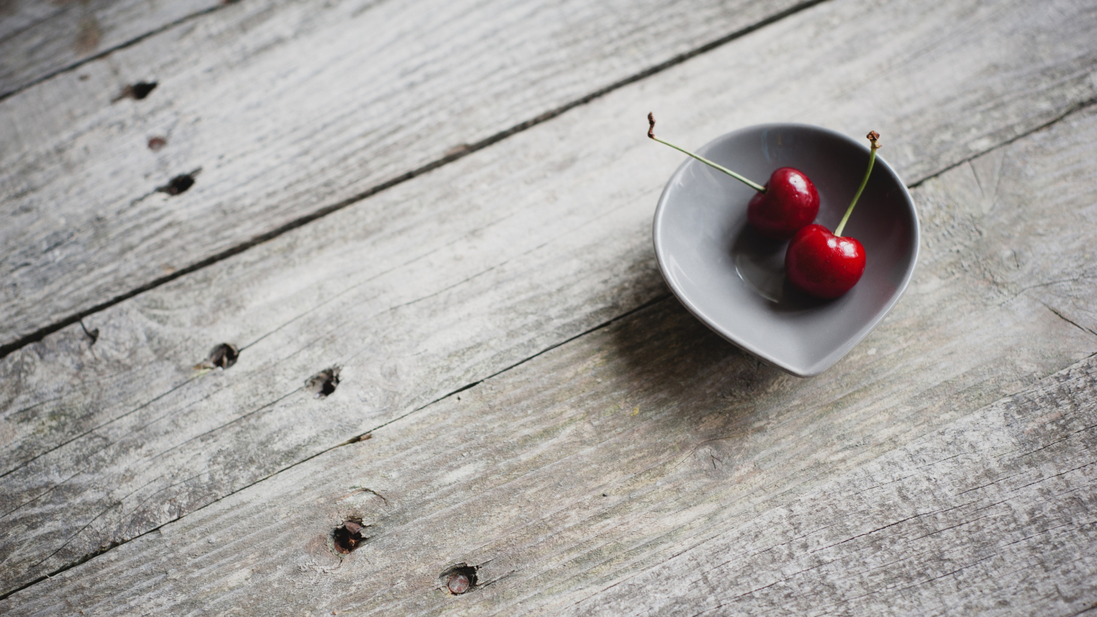 Sfondi Two Red Cherries On Plate On Wooden Table 1600x900