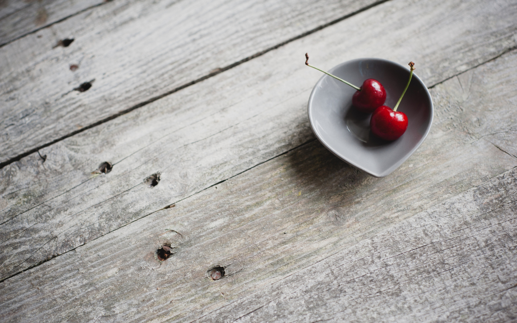 Das Two Red Cherries On Plate On Wooden Table Wallpaper 1680x1050