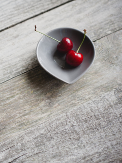 Обои Two Red Cherries On Plate On Wooden Table 240x320