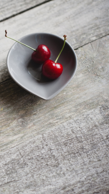 Das Two Red Cherries On Plate On Wooden Table Wallpaper 360x640