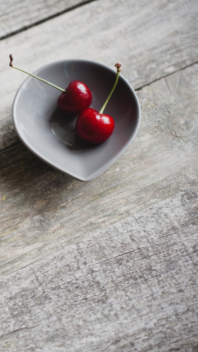 Обои Two Red Cherries On Plate On Wooden Table 640x1136