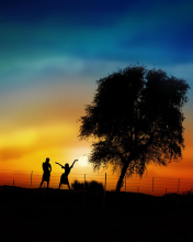 Das Couple Silhouettes Under Tree At Sunset Wallpaper 176x220