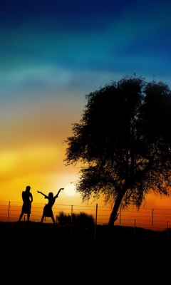 Das Couple Silhouettes Under Tree At Sunset Wallpaper 240x400