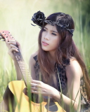 Обои Pretty Girl In Grass Playing Guitar 128x160