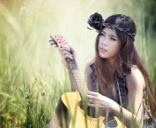 Обои Pretty Girl In Grass Playing Guitar 176x144