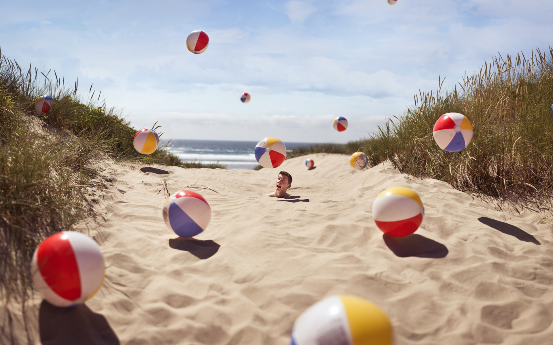 Beach Balls And Man's Head In Sand wallpaper 1920x1200