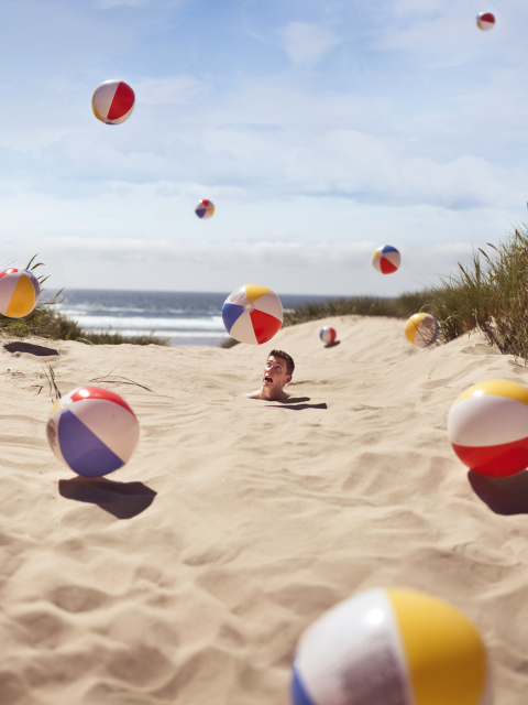 Sfondi Beach Balls And Man's Head In Sand 480x640