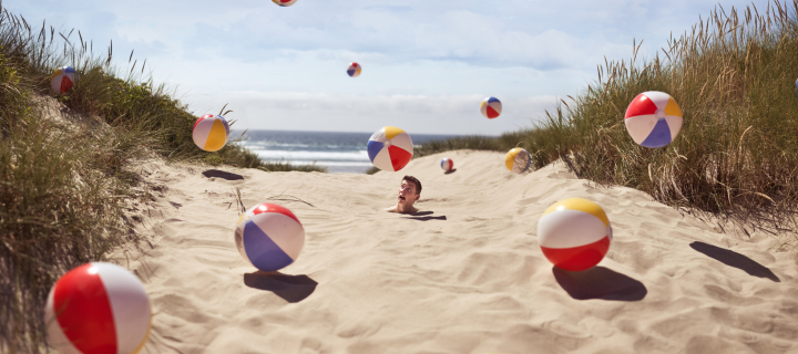 Fondo de pantalla Beach Balls And Man's Head In Sand 720x320