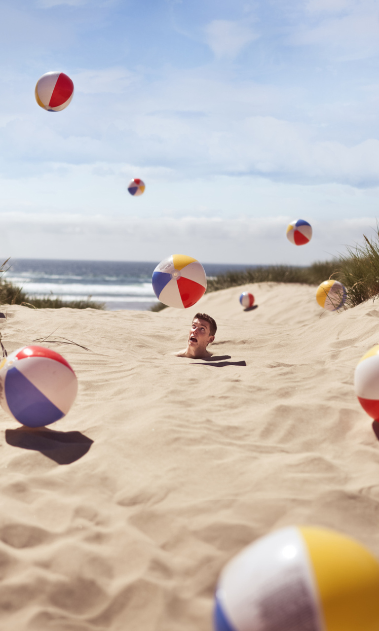 Sfondi Beach Balls And Man's Head In Sand 768x1280
