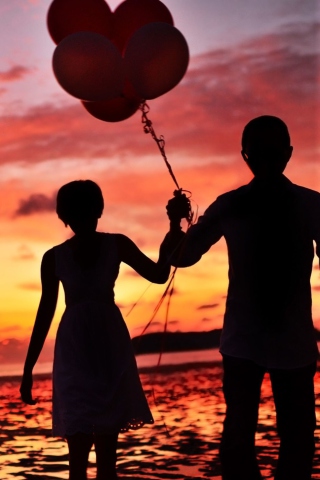 Fondo de pantalla Couple With Balloons Silhouette At Sunset 320x480