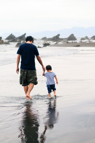 Father And Child Walking By Beach wallpaper 320x480