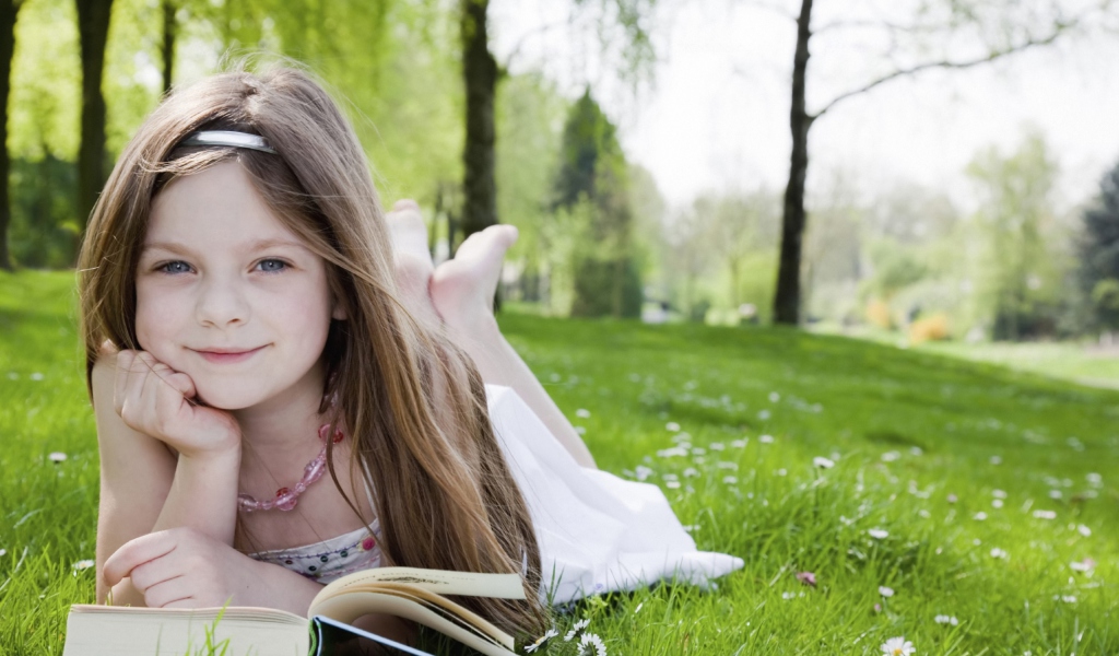 Cute Little Girl Reading Book In Garden wallpaper 1024x600