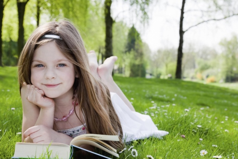 Cute Little Girl Reading Book In Garden wallpaper 480x320