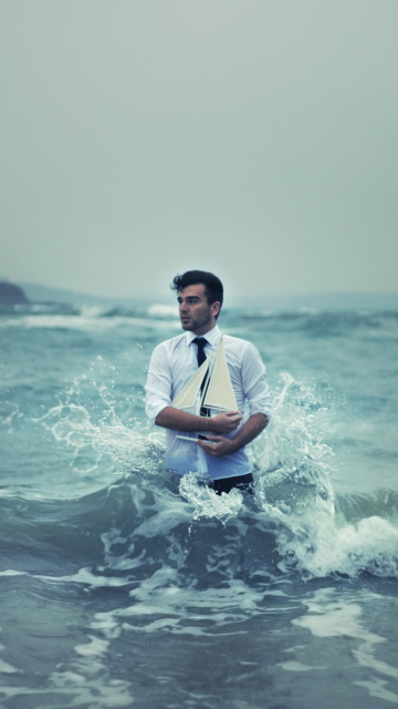 Das Man With Ship In Hands And Ocean Waves Around Him Wallpaper 360x640