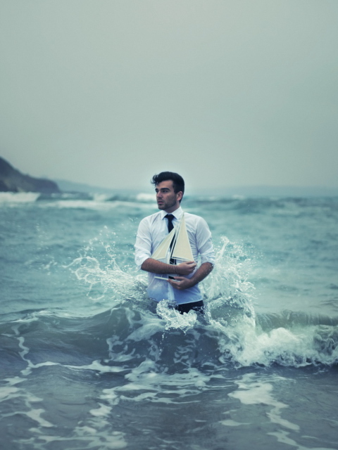 Обои Man With Ship In Hands And Ocean Waves Around Him 480x640