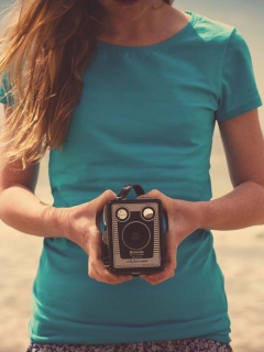 Girl On Beach With Retro Camera In Hands wallpaper 240x320